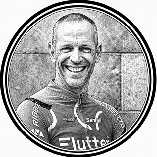 Black and white portrait of a smiling person wearing a cycling jersey with visible brand logos.