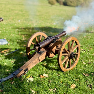 Small  2pound field gun on wheels firing in a grassy field. Using Naval strength gin.
