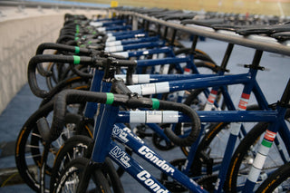 Row of blue bicycles with 'Condor' branding on a concrete surface.