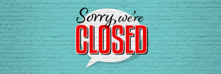 Closed sign with 'Sorry, we're closed' text on a blue brick wall background