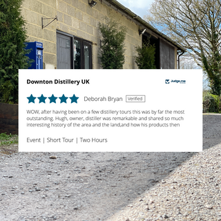 Downton Distillery UK with a review overlay on a clear day.